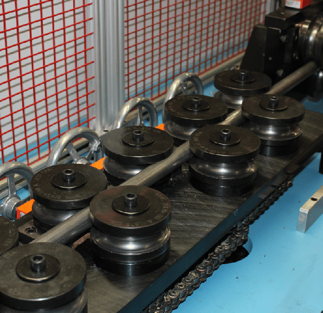 A tube being forced thru a series of roll dies - Winton Machine USA